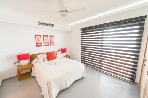 a bedroom with a bed and a large window at Aligio Apart-hotel & Spa - Las Terrenas in Las Terrenas