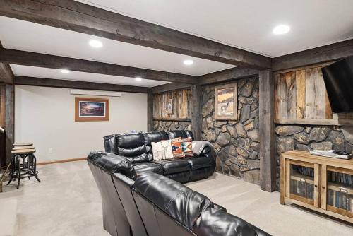sala de estar con muebles de cuero y pared de piedra. en Secluded Stay in a Wonderful Creekside Getaway, en Custer