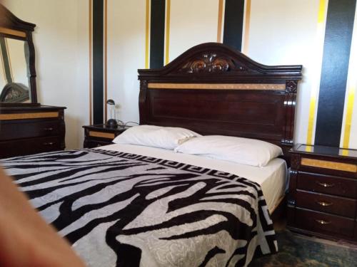 a zebra print bed in a bedroom with two dressers at La casa de Wael in Ifrane