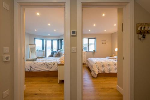 a bedroom with two beds and a hallway with two beds at Sandpiper Cottages in Newquay