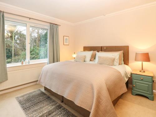a bedroom with a bed and a window at Brundall House in Norwich