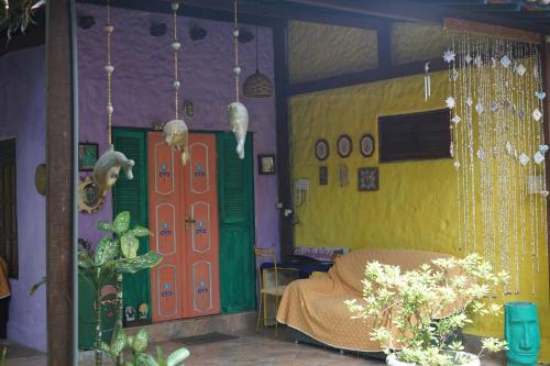 a room with colorful walls and a door and flowers at Recanto da Nara in Pipa