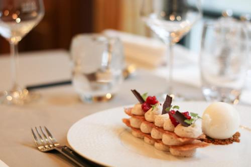 a white plate with shrimp on a table with wine glasses at Koener Hotel & Spa in Clervaux