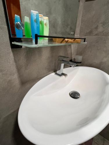 a white bathroom sink with a mirror above it at Ceylon Resort in Wilpattu