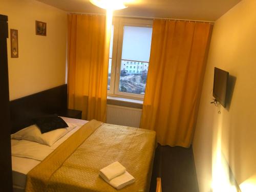 a small bedroom with a bed and a window at Sosnowe Zacisze in Białystok