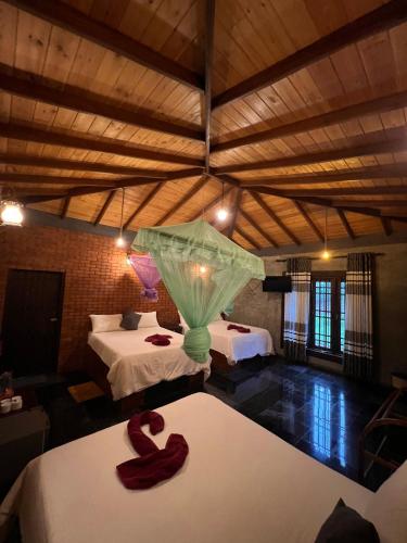a room with two beds and a vase on the floor at Ceylon Resort in Wilpattu
