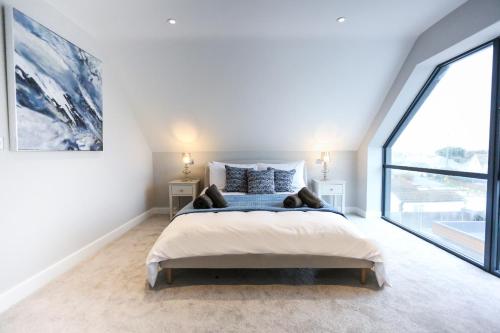 a bedroom with a large bed and a large window at Ocean View - Bracklesham Bay in Chichester