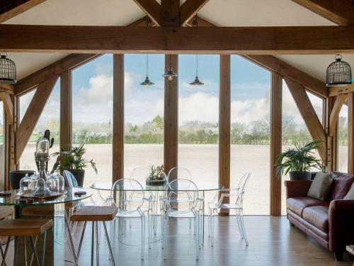 a dining room with a glass table and chairs at Country Escape at the Granary in Colchester