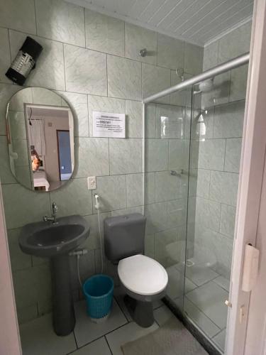 a bathroom with a toilet and a sink and a shower at Pousada carioca in São João da Barra