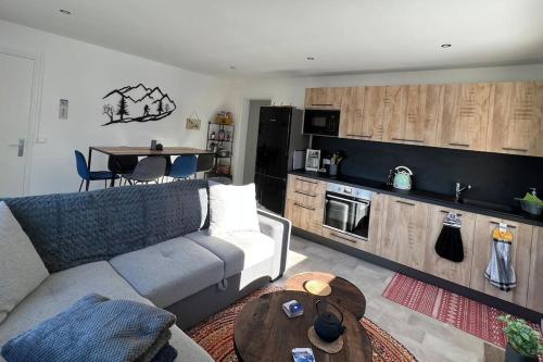 uma sala de estar com um sofá e uma mesa em Appartement cocooning 2 chambres em Gourette