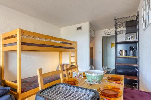 a room with a table and a bunk bed at Les Laurentides in Villarembert