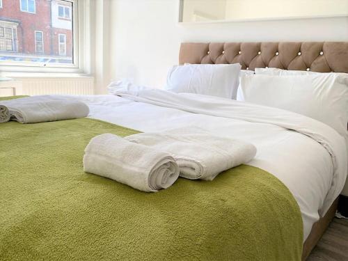 a large bed with white sheets and towels on it at The Four Bays Apartment - Cliftonville Central - By Goldex Coastal Breaks in Kent