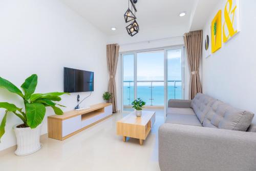 sala de estar con sofá y TV en Gold Sea Apartment Vung Tau-The Palm Sea View, en Vung Tau