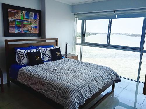 a bedroom with a bed and a large window at Apartments Puerto Santa Ana in Guayaquil