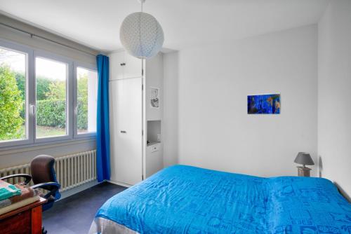 um quarto com uma cama azul e uma janela em Ty Bigorn'oh em Bénodet