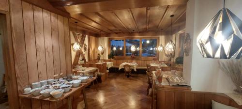 オルティゼーイにあるガルニ パノラミックのテーブルと椅子が備わるレストラン