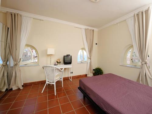 a bedroom with a bed and a desk with a tv at Lae Domus in Atrani