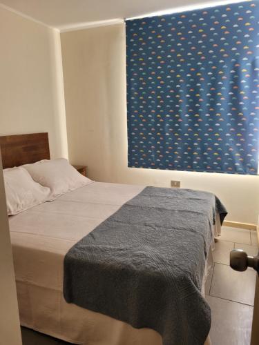 - une chambre avec un lit et une grande fenêtre dans l'établissement Departamento en Curicó, à Curicó