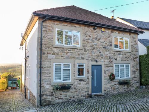 a brick house with a blue door and windows at Glenhurst in Dronfield