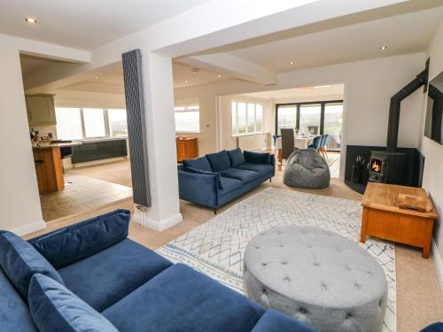 a living room with blue couches and a fireplace at Glenhurst in Dronfield