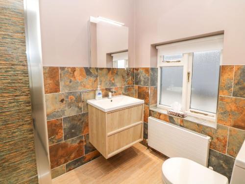 a bathroom with a sink and a mirror at Glenhurst in Dronfield