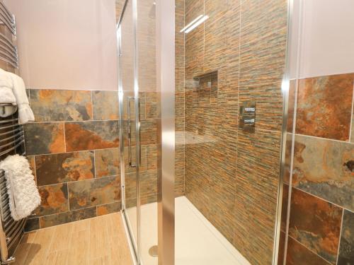 een badkamer met een douche en een glazen deur bij Glenhurst in Dronfield