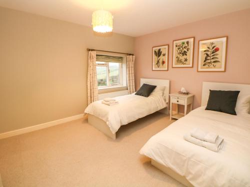 a bedroom with two beds and a window at Glenhurst in Dronfield
