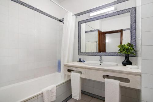 bagno con lavandino, vasca e specchio di Apartamento AnaMar by Sunnyway ad Albufeira