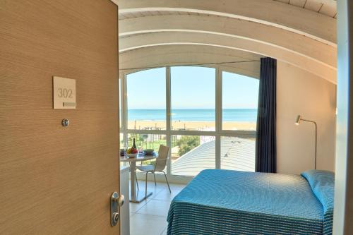a bedroom with a bed and a view of the ocean at JUST SUITES in Cervia