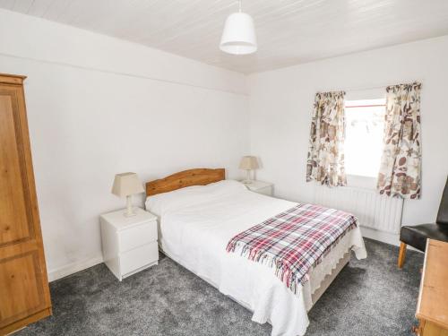 a bedroom with a white bed and a window at Ti Sonny in Glinsk