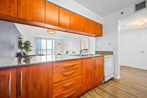 a large kitchen with wooden cabinets and a sink at Amazing cozy Condo in Brickell Miami in Miami