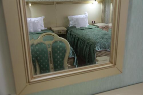 a reflection of a bedroom with two beds in a mirror at Hotel Majestic in Iaşi