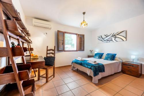 Un dormitorio con una cama, un escritorio y literas. en Villa Sa Tanca Den Lloses, en Can Furnet