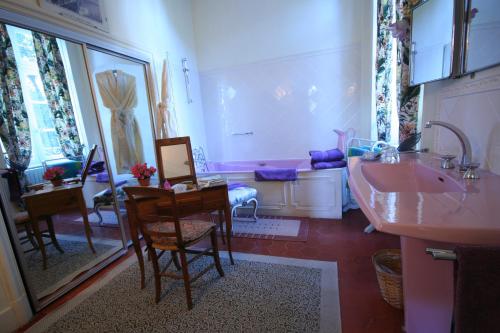 a bathroom with a sink and a table and chairs at Chateau de Raissac in Béziers