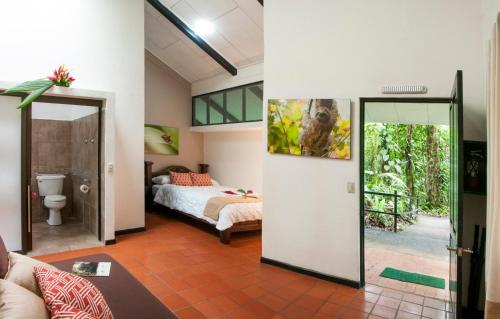 a bedroom with a bed and a bathroom at Tapirus Lodge and Reserve in Carrillo