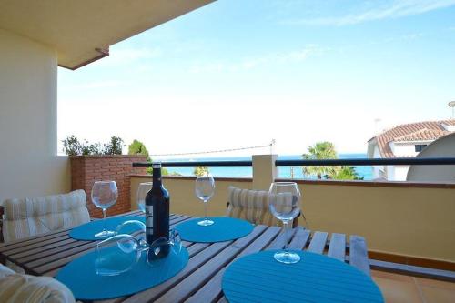 stół z butelką wina i kieliszkami na balkonie w obiekcie Benalmadena Beach Apartamento con Vistas al mar y Parking Privado Incluido w mieście Benalmádena