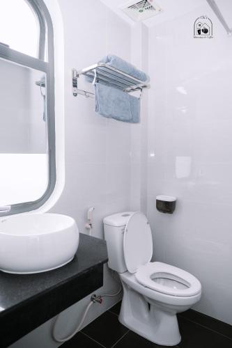 a white bathroom with a toilet and a sink at Chi's Homestay & Coffee in Hue