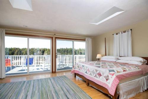 ein Schlafzimmer mit einem Bett und einem Balkon in der Unterkunft Phenomenal Home on Coast of Maine in Phippsburg