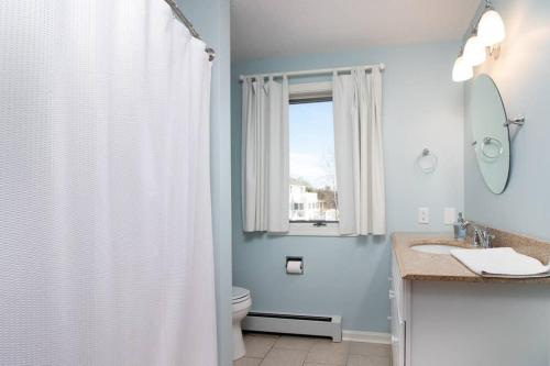 baño con aseo y lavabo y ventana en Phenomenal Home on Coast of Maine, en Phippsburg