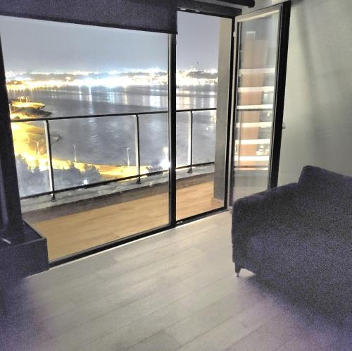 a room with a large window with a view of the ocean at Amazing Seafront new 4 Bedrooms flat with free Wi-Fi in Buyukcekmece