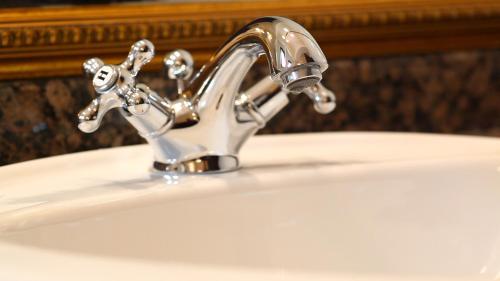 a bathroom sink with a silver faucet at Hotel Majestic in Iaşi