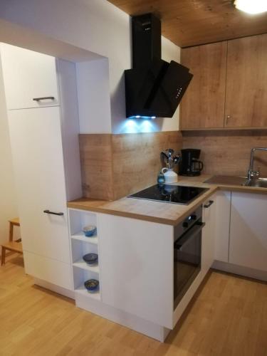 a kitchen with white cabinets and a stove top oven at Haus Jenewein in Wildschönau