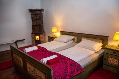 a bedroom with a large bed with a red blanket at Casa Sub Magrin in Satu Bătrîn