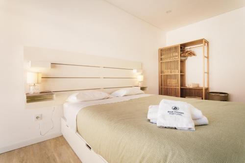 a bedroom with a large bed with towels on it at Best Houses 29 - Apartamento das Vinhas in Peniche