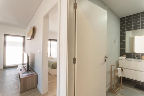 een badkamer met een deur naar een slaapkamer bij Best Houses 29 - Apartamento das Vinhas in Peniche