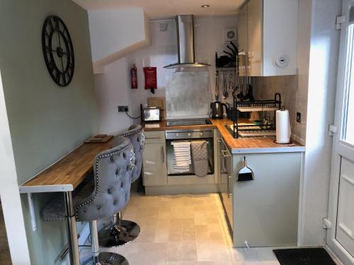 a small kitchen with a counter and a stove at Cardiff Coach House with Hot Tub & Log Fire in Cardiff
