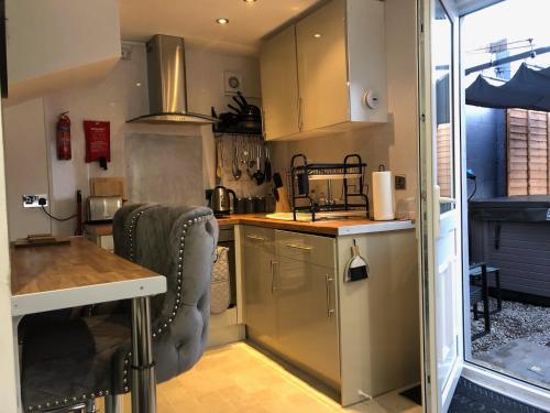 a kitchen with stainless steel cabinets and a counter at Cardiff Coach House with Hot Tub & Log Fire in Cardiff