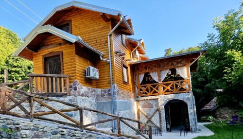 a log cabin with a porch and a balcony at Kuća za odmor Čarolija in Jastrebarsko