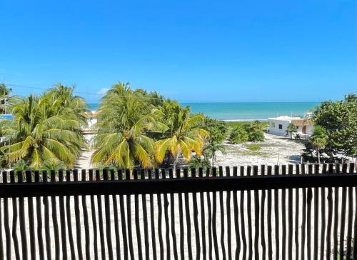 a view of a beach with palm trees and the ocean at Dos Mares Barefoot Luxury in El Cuyo