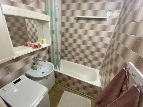 a bathroom with a sink and a toilet and a tub at Apartmán Jasmin Levice in Levice